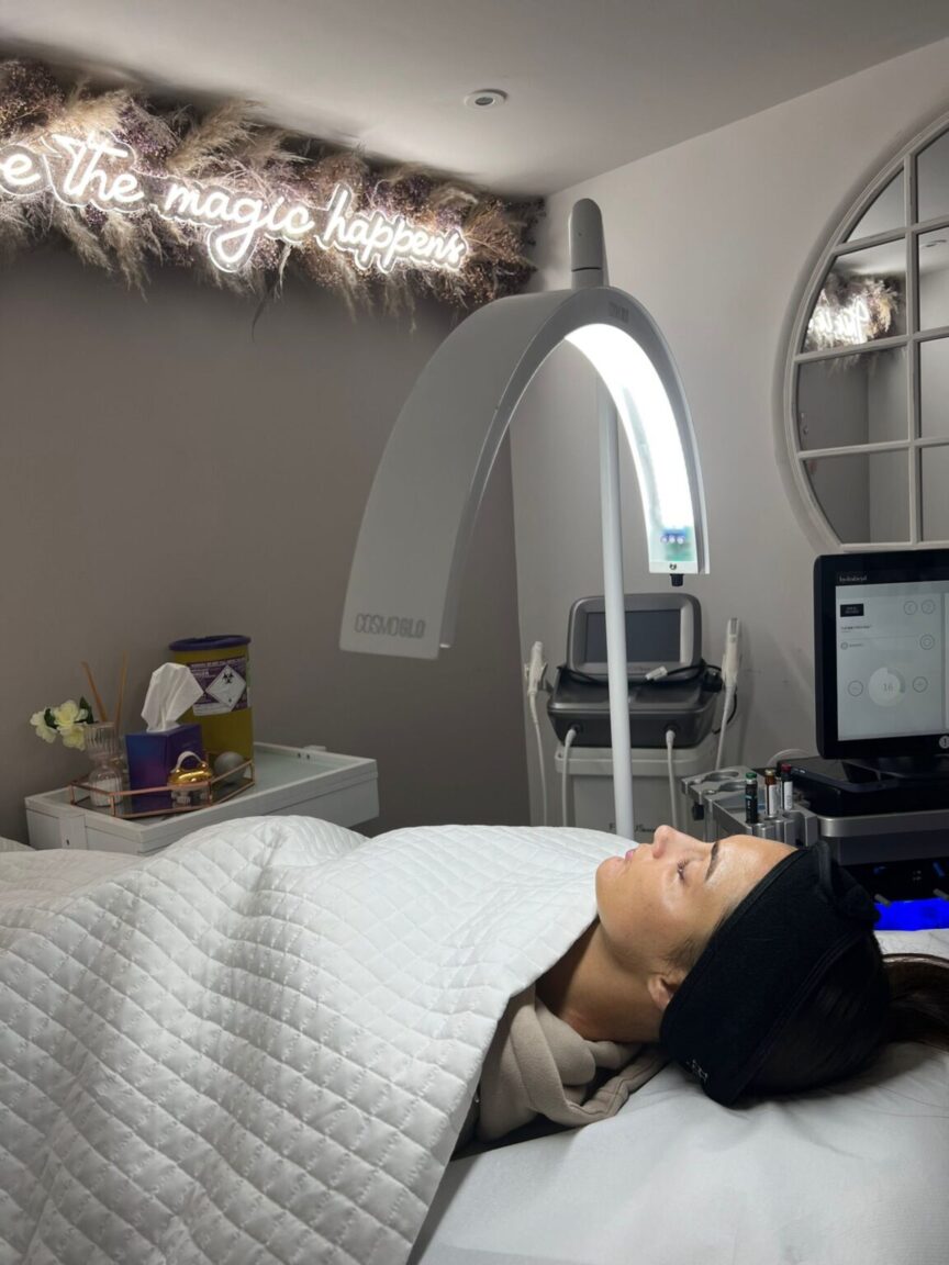 Woman receiving Dermalux Light Therapy at an aesthetic clinic for glowing, event-ready skin.